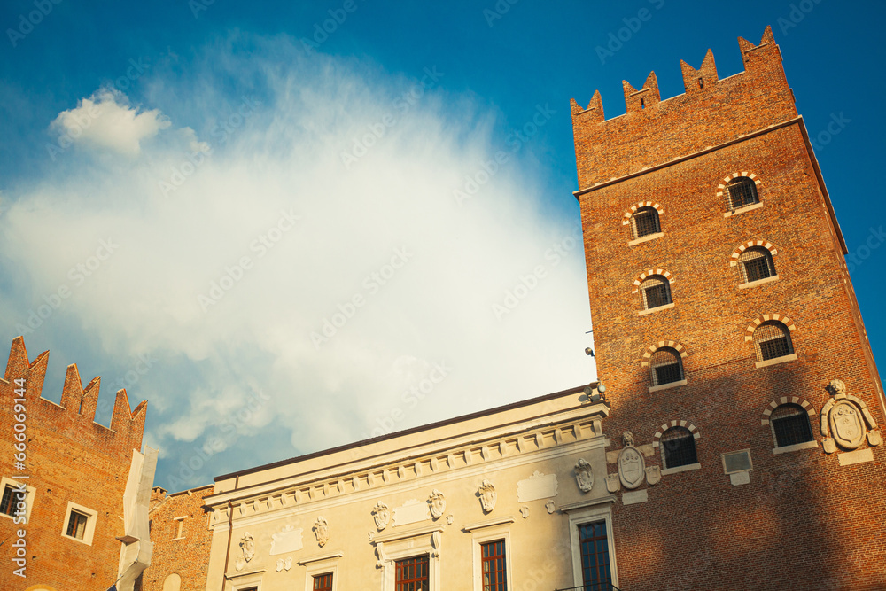 Fair Verona concept. Palazzo di Consignorio on Piazza dei Signori in old city centre. Amazing white clouds in blue sky. Text space. Outdoor shot with perspective