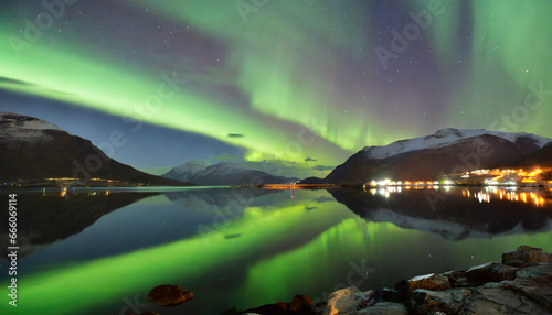 Northern lights, also known as the Aurora Borealis, captured amidst two fjords in Troms