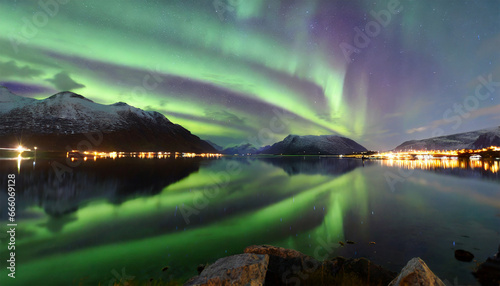 Northern lights, also known as the Aurora Borealis, captured amidst two fjords in Troms