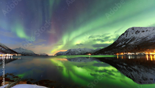 Northern lights, also known as the Aurora Borealis, captured amidst two fjords in Troms