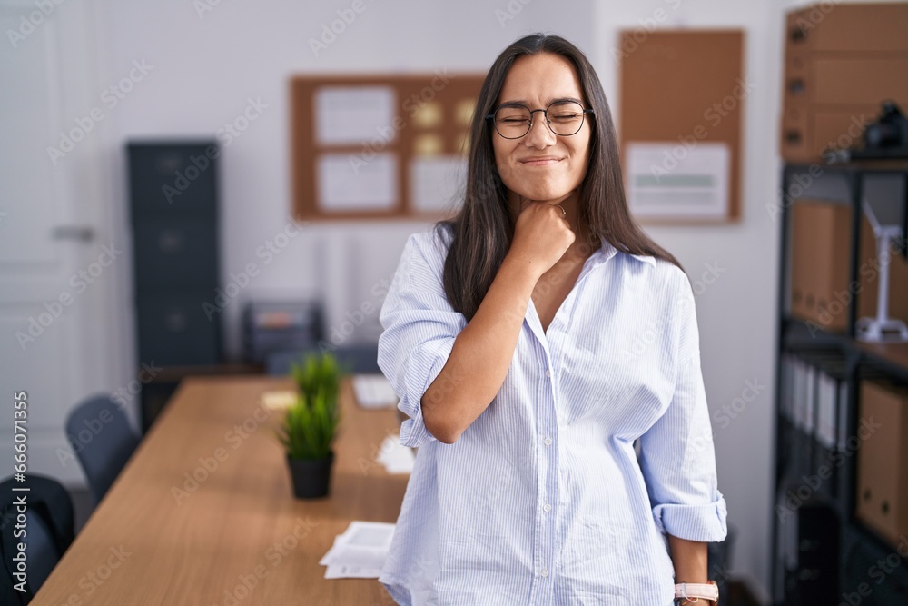 Young hispanic woman at the office touching painful neck, sore throat for flu, clod and infection Young hispanic woman at the office touching painful neck, sore throat for flu, clod and infection