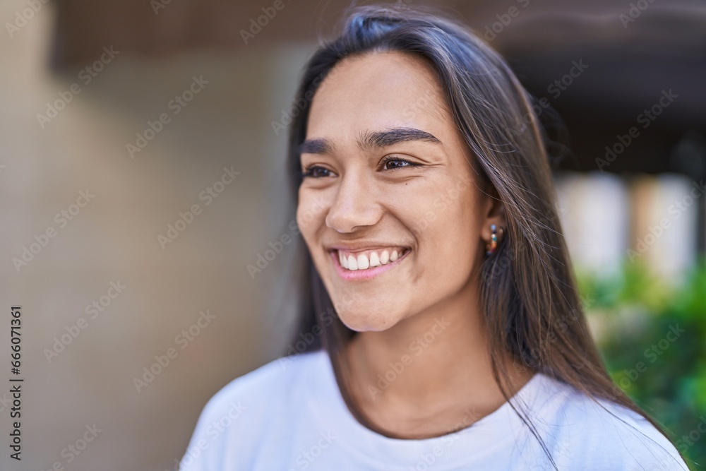 Young beautiful hispanic woman smiling confident looking to the side at street Young beautiful hispanic woman smiling confident looking to the side at street