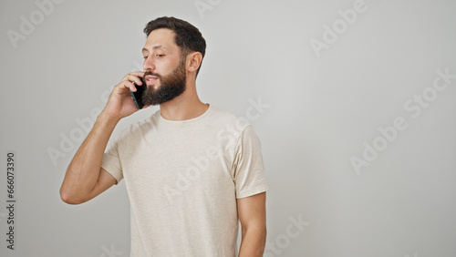 Young hispanic man talking on the smartphone over isolated white background