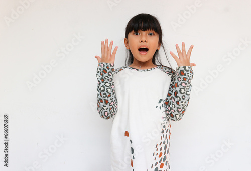 A beautiful little girl wearing a leopard sleeve pattern raised her hands while feeling surprised