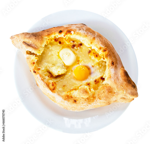 traditional Georgian dish of cheese-filled bread - khachapuri in adjarian style with egg and butter on white plate isolated on white background photo