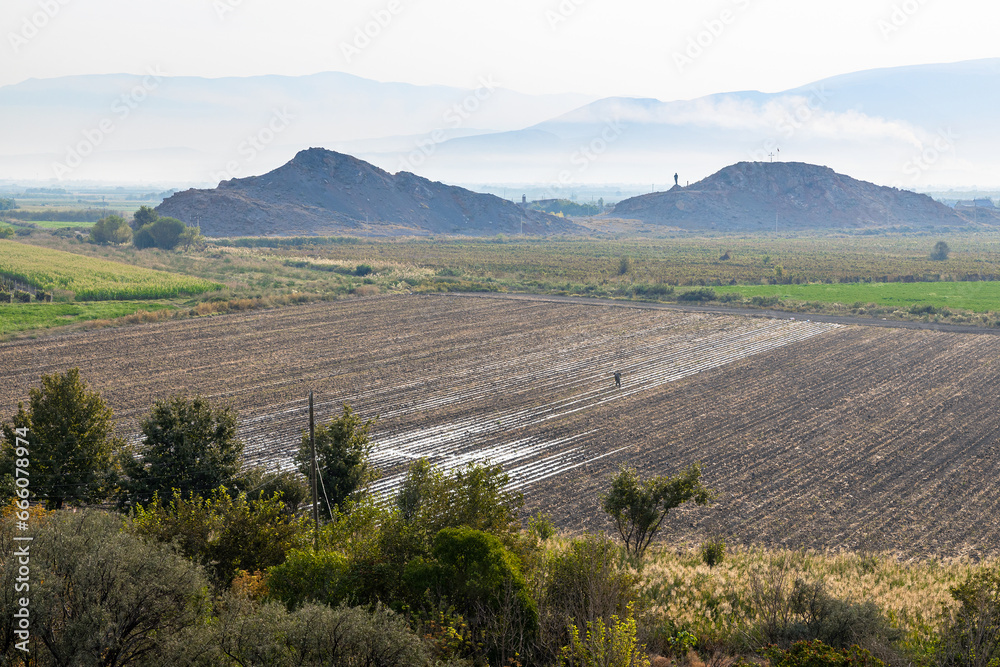Obraz premium cultivated agricultural land and fields in Ararat plain in Armenia on autumn morning with fog on mountains on background