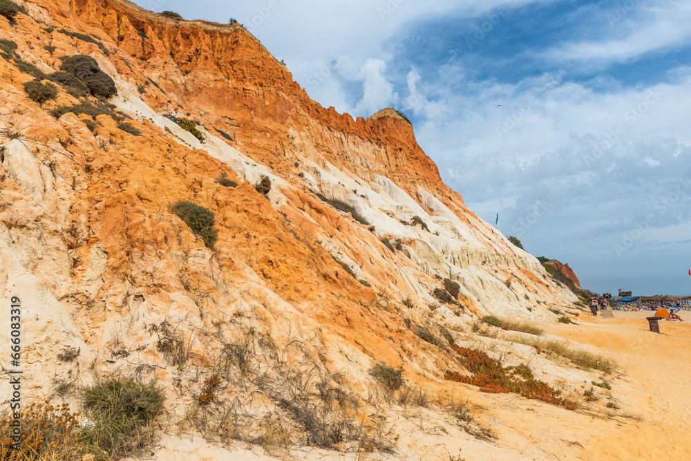 Red cliffs on sandy beach in Algrave, Portugal at sunny day