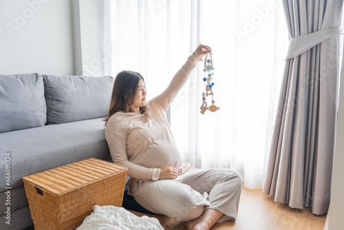 Pregnant asian woman getting ready for the maternity hospital preparing and planning baby clothes for new baby of pregnancy packing for maternity hospital at home