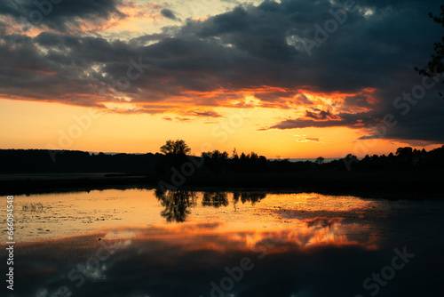 Sunset reflected in the lake © Cezary