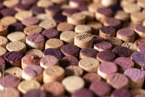 Close up of many extracted wine corks with various intensity red color and focus on 2019 marking