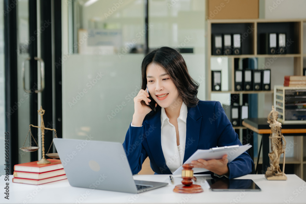 Asian lawyer woman working with a laptop and tablet in a law office. Legal and legal service concept. Looking at camera