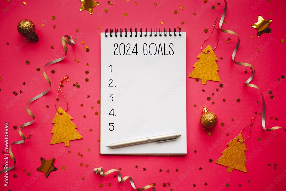 New Year goals List 2024 with notebook written in handwriting about plan listing of new year goals and resolutions setting. flat lay style. Christmas planning concept - obrazy, fototapety, plakaty 
