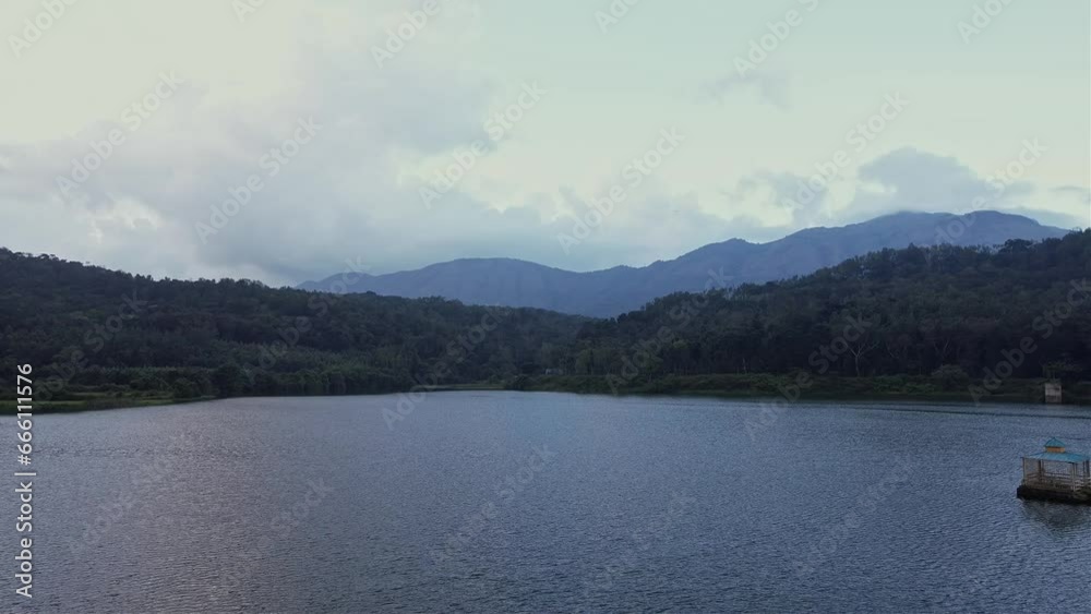 A cinematic drone view of a river amidst mesmerising dense forest and mountains A cinematic drone view of a river amidst mesmerising dense forest and mountains
