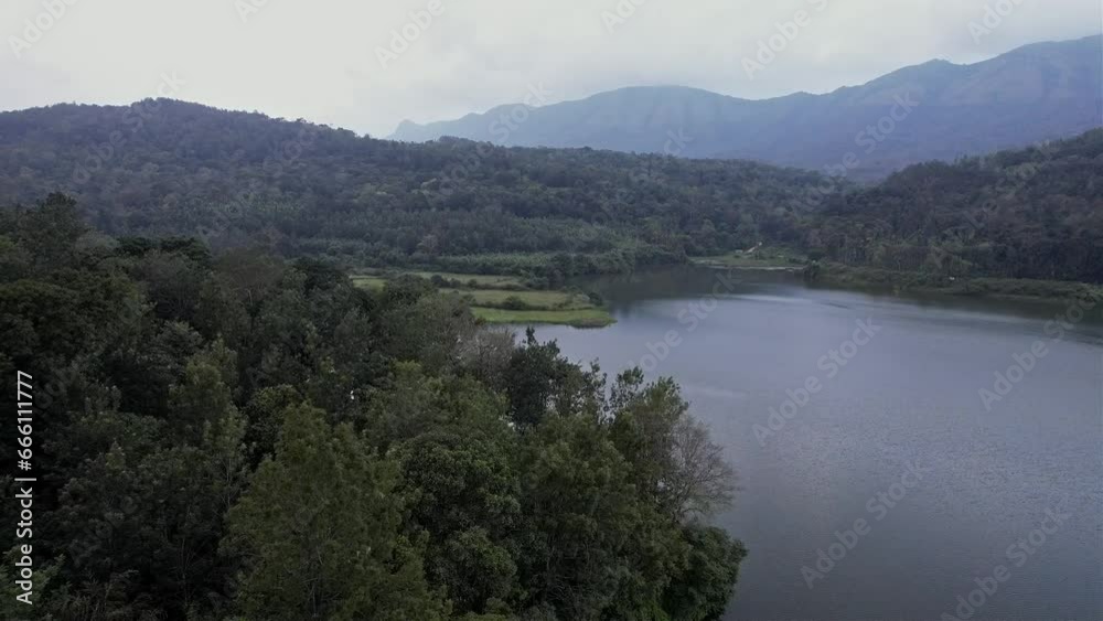 A cinematic drone view of a river amidst mesmerising dense forest and mountains A cinematic drone view of a river amidst mesmerising dense forest and mountains