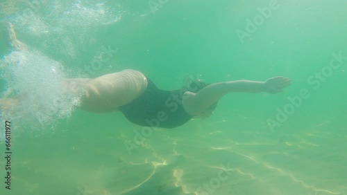 Pregnant woman underwater swimming in tropical sea. Healthy and active pregnancy. Young expecting mom on summer beach vacation before baby birth. Water fun. Travel during pregnancy