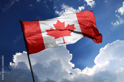 national flag of Canada waving in the wind on a clear day.