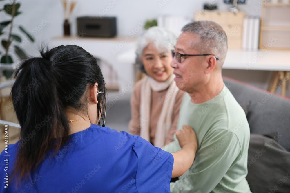 Attentive doctor or healthcare worker giving professional advice to senior couple during home visit Attentive doctor or healthcare worker giving professional advice to senior couple during home visit