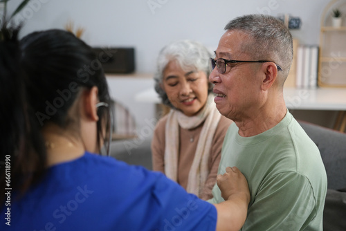 Attentive doctor or healthcare worker giving professional advice to senior couple during home visit