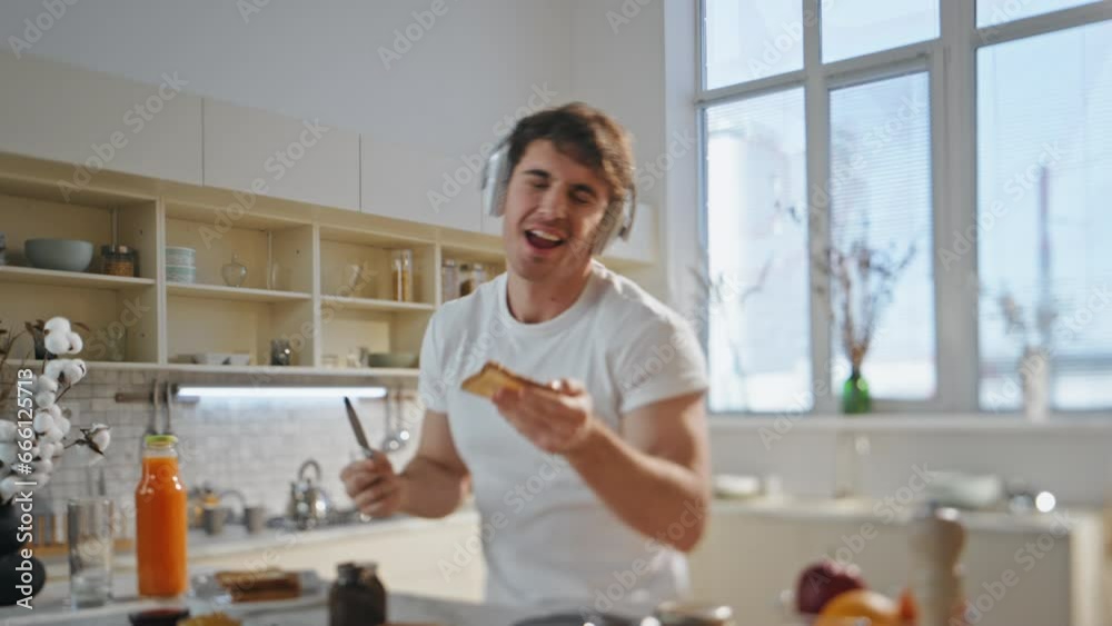 Guy earphones preparing food dancing home close up. Man listening music kitchen Guy earphones preparing food dancing home close up. Man listening music kitchen