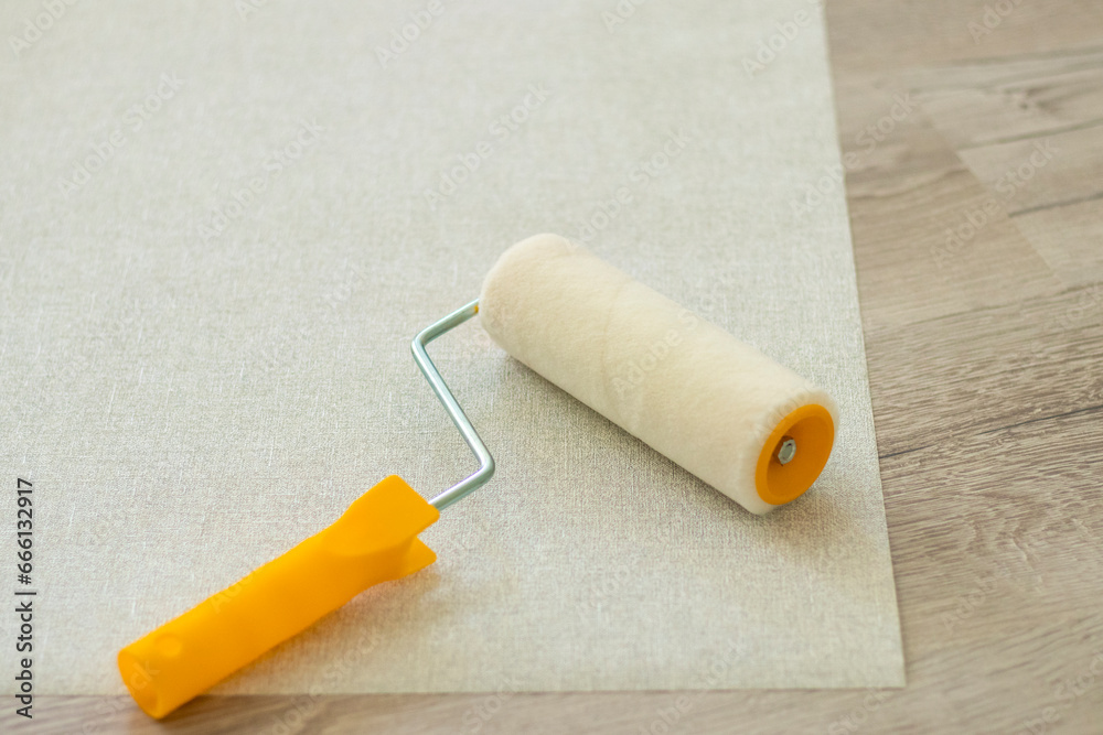 Obraz premium Gray textured wallpaper rolls on wooden background. copy space. Professional Wall Paint Roller Brush Handle Tool Replacable. Portable Sponge Paint Roller Brush Handle DIY Wall Painting Tool Wall Decor