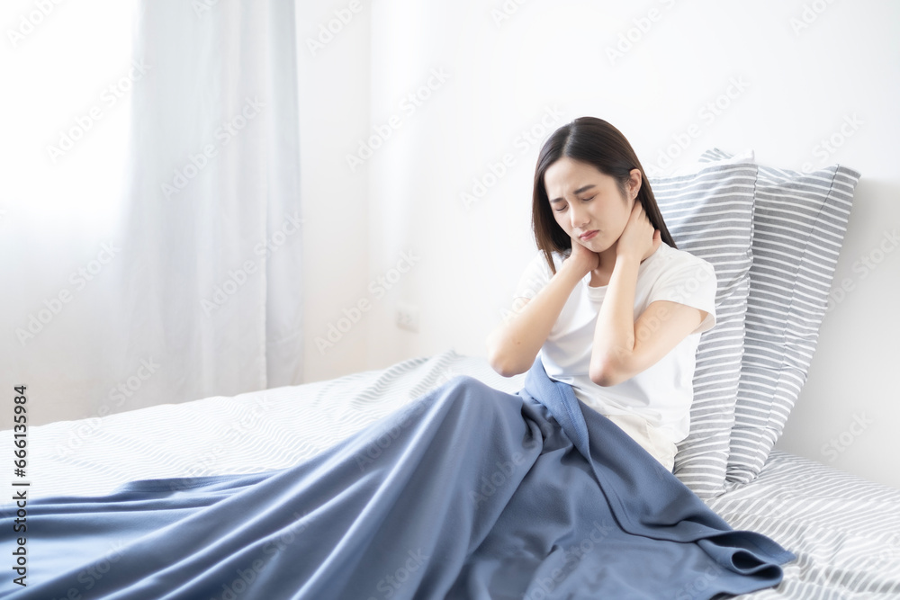 Young Asian lazy woman got neck ache after waking up in morning, woman feel pain at neck after woken up.