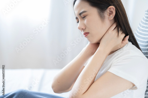Young Asian lazy woman got neck ache after waking up in morning  woman feel pain at neck after woken up.