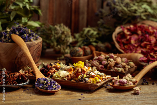 Various dried medicinal plants  herbs  and flowers on an old wooden background.