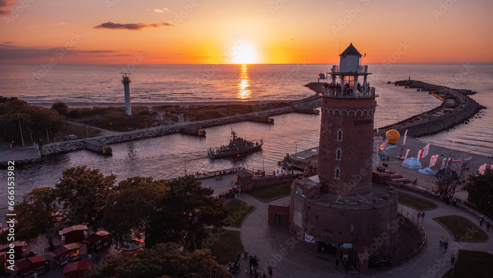 A lighthouse at sunset. The harbour and the Baltic Sea in the background of Kolobrzeg. Taken from a drone. Kołobrzeg is a city in Poland.