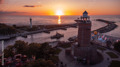 A lighthouse at sunset. The harbour and the Baltic Sea in the background of Kolobrzeg. Taken from a drone. Kołobrzeg is a city in Poland.