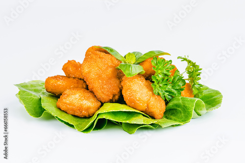 Fast homemade food at home. Breaded chicken nuggets.Breaded Chicken Inner Fillet with green lettuce leaves on a White Background.Chicken Breaded Raw Meat,Fillet.Chicken breaded schnitzels.Fast cooking