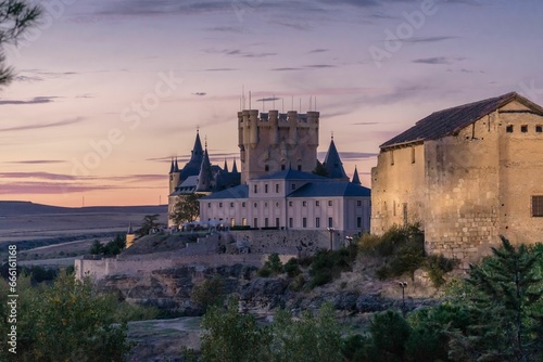 Beautiful views of the Alcazar of Segovia at sunset illuminated by the pink sky of the setting sun