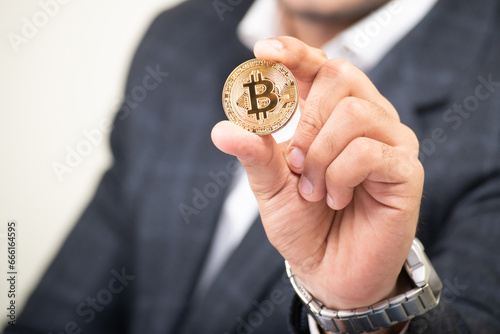 Businessman showing bitcoin in his hand