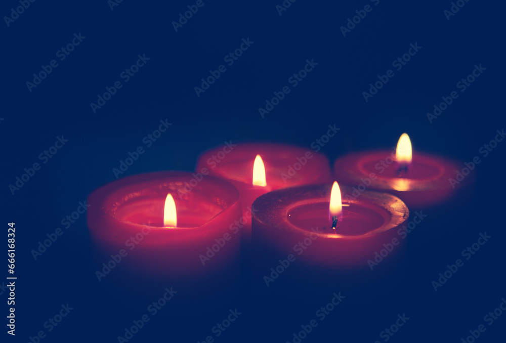 Four burning red Advent candles on black background. Four burning red Advent candles on black background.