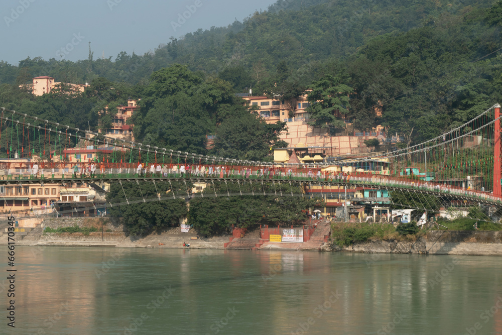 Fototapeta premium Beautiful view of ram jhula with ganga river and mountains in rishikesh, uttarakhand