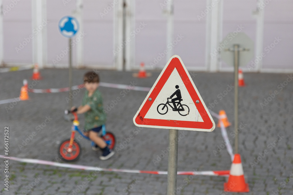 Warning sign near children riding bikes.