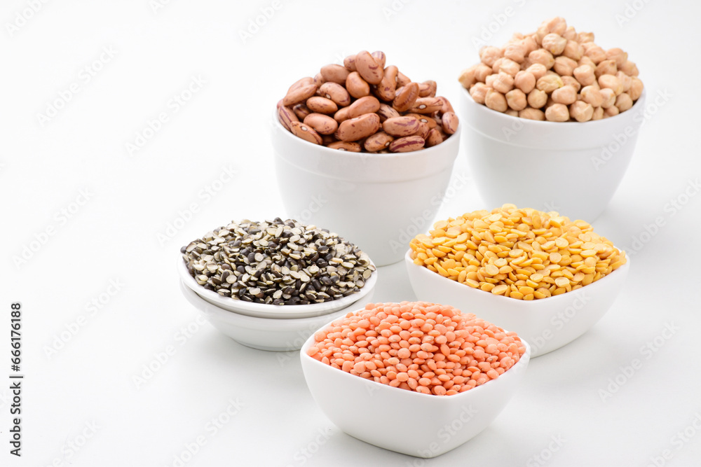 Uncooked lentils legumes and beans in bowl on white background assorted