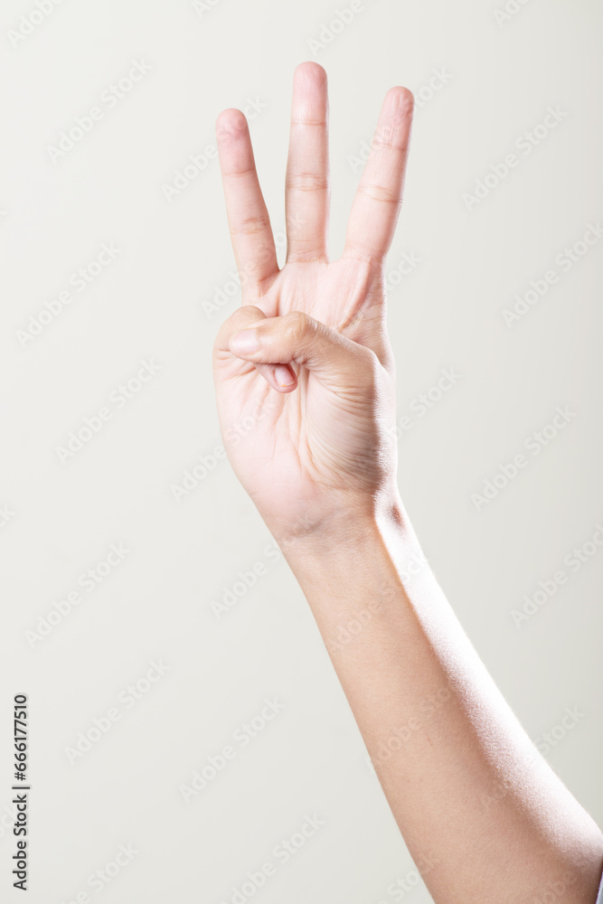 Fototapeta premium Hand showing three gesture isolated on grey background