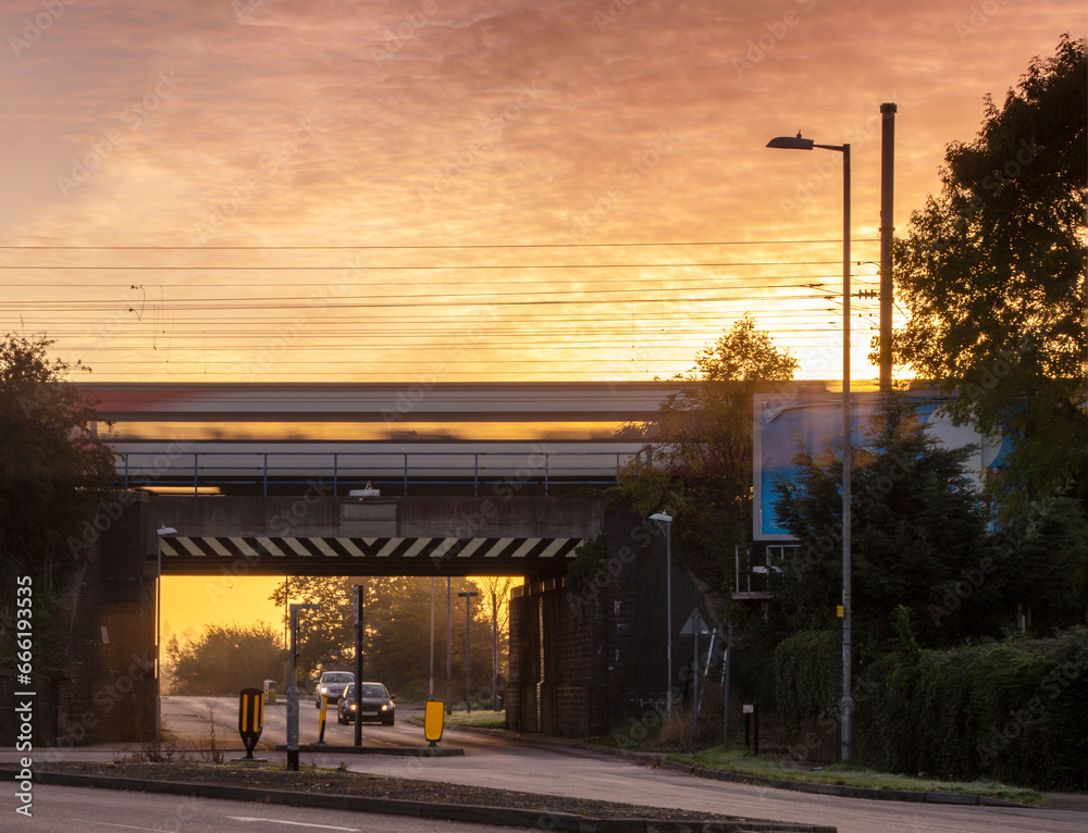 Train rushing across a rail-bridge at sun rise, landscape view.