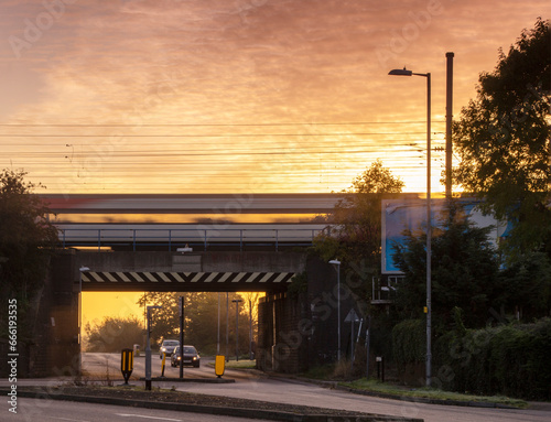 Train rushing across a rail-bridge at sun rise, landscape view. photo