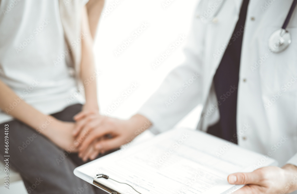 Doctor and child patient. The physician is holding clipboard and reassuring a boy. The concept of ideal health in medicine Doctor and child patient. The physician is holding clipboard and reassuring a boy. The concept of ideal health in medicine