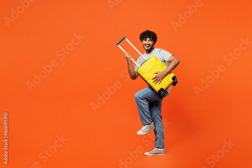 Traveler woman wear casual clothes hold suitcase pov play guitar isolated on plain orange red background studio. Tourist travel abroad in free spare time rest getaway. Air flight trip journey concept. #666195910