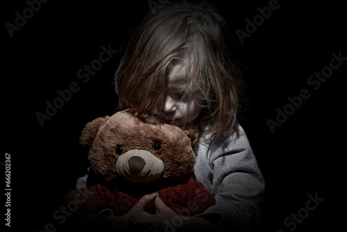 Sad little girl embracing her teddy bear - feels lonely - if you are small girl teddy bear is willing to be your best friend - vintage filter applied photo