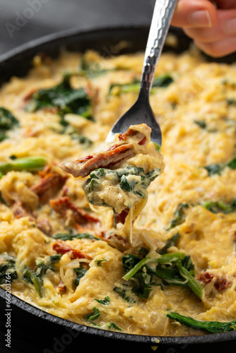 Creamy spaghetti squash pasta with parmesan cheese and sun dried tomato sauce in iron cast pan photo