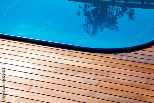 Brown ipe wood deck and blue swimming pool edge