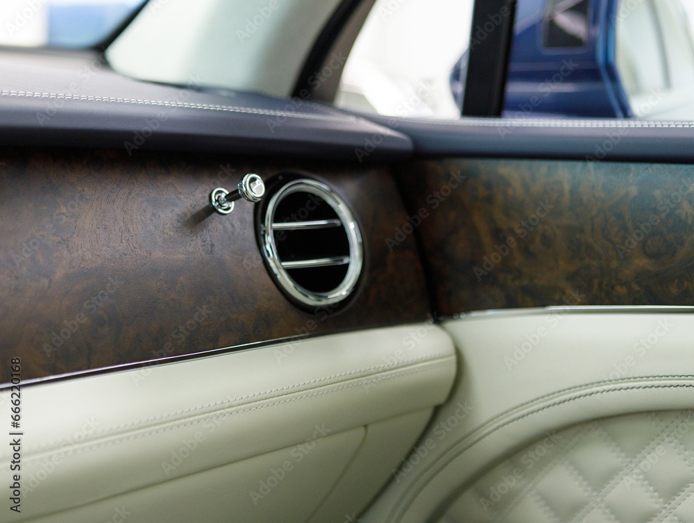 medium shot of a luxury car interior with natural wood and leather trim