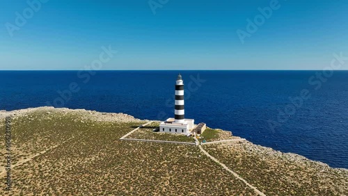 pristine lighthouse overlooking the clear blue waters of Minorca. photo