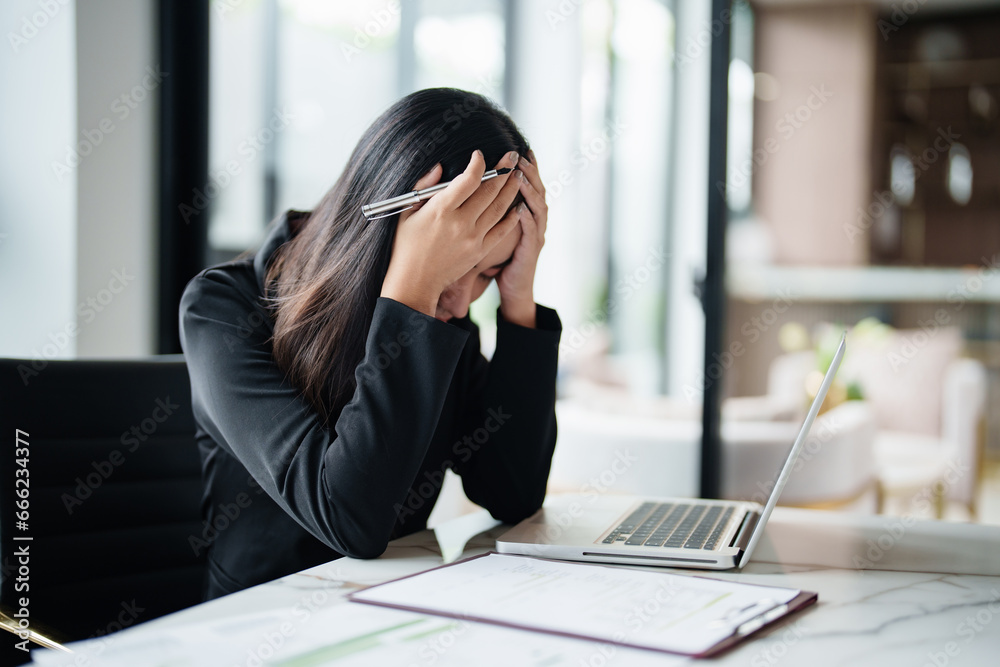 Businesswoman headache with stress and take a break while working about calculating tax in office.. Businesswoman headache with stress and take a break while working about calculating tax in office..
