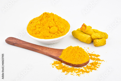 Turmeric powder in spoon on white background photo