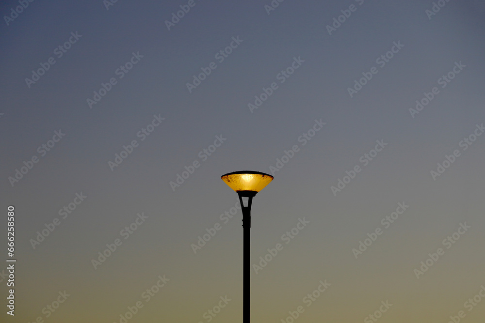 Street lights in the park at dusk with lights on Street lights in the park at dusk with lights on