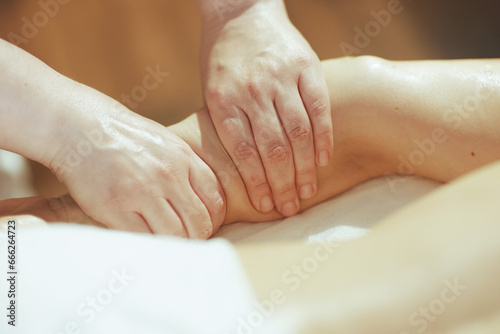 Closeup on medical massage therapist massaging clients arm